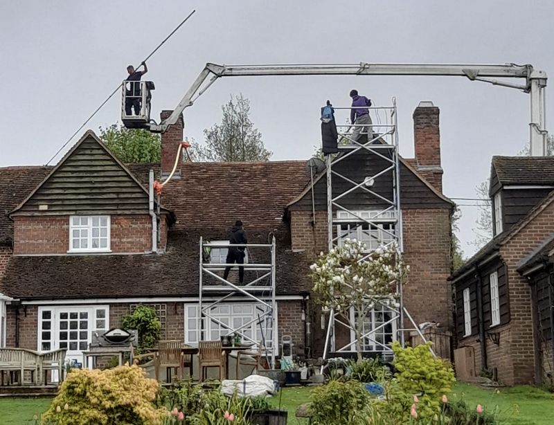 The Moss Cleaners using cherry picker and scaffolding to clean roof safely and professionally in Chiswick, {{COUNTY}}